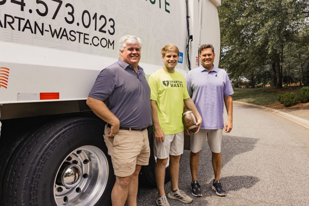 Spartan Waste founders Mark Nelson and Mark Mullen with Wofford Football player Atkins Roberts.