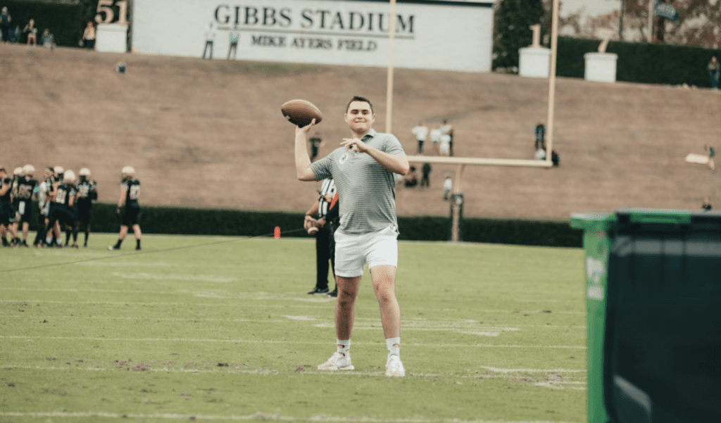 Student throwing football at Wofford Football half-time event sponsored by Spartan Waste.